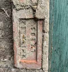 Blocked brick opening beside a green door